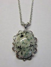 A beautiful custom-cut emerald in matrix mounted in a pendant.