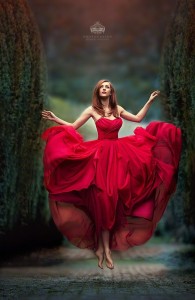 Beautiful woman floating in a red dress. 