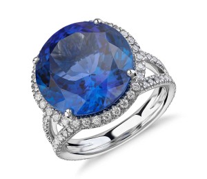 Tanzanite and Diamond Halo Split Shank Ring in 18k White Gold (10.88ct center) (14.2mm)     Perfectly stunning, this gemstone and diamond ring features an impressive vivid tanzanite with a pavé diamond halo intricately set in 18k white gold.  