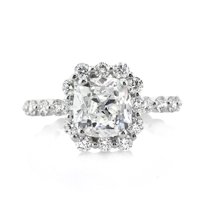 This enchanting antique cushion cut diamond engagement ring has a spectacular combination. It all starts with the mesmerizing 2.40ct old mine brilliant, with its chunky facets, amazing brilliance and exceptional cut. It is GIA certified at F-SI1. This exceptionally white and eye clean gem is showcased beautifully in this shared prong design, made in high polish 18k white gold. The round brilliant cut diamonds set in the halo and shank showcase their own shape beautifully with minimal metal showing. The ring's dainty design allows for the diamonds to pop. It is stunning from every angle.