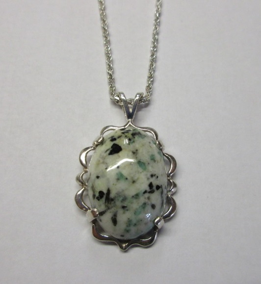 A beautiful custom-cut emerald in matrix mounted in a pendant.