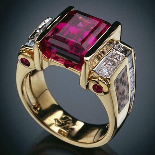 Spectacular 8 Ct emerald cut rubellite tourmaline ring, 4 tube set ruby cabochons, inlaid pertrified palm, and 26 diamonds both channel-set and pave.