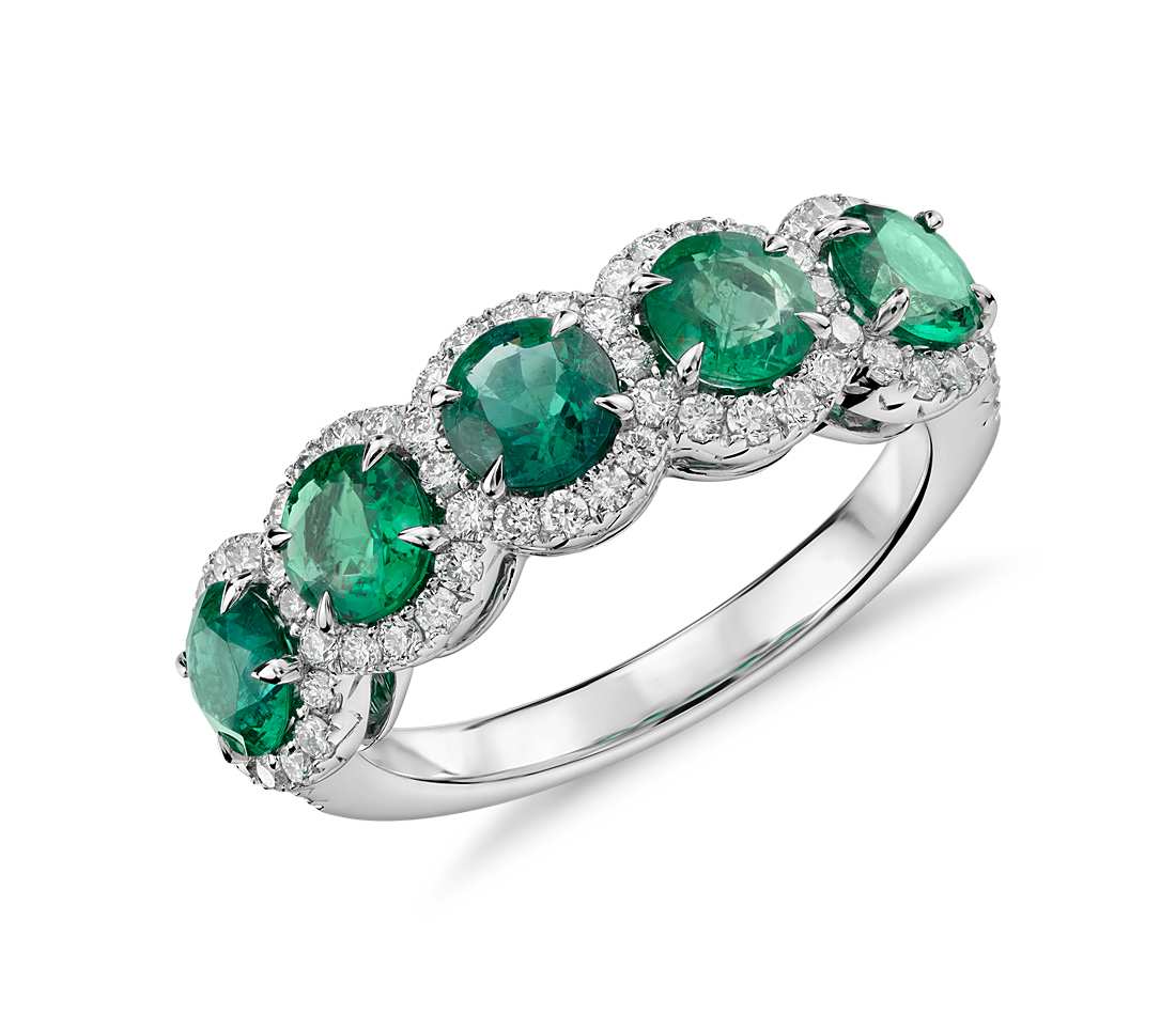 Emerald with Diamond Five-Stone Halo Ring in 18k White Gold (4.5mm) Elegant in design, this ring features vivid green emerald gemstones surrounded by a halo of brilliant diamonds framed in 18k white gold. Due to their delicate nature, emeralds require special care. Removal of this ring when active will maintain beauty and ensure every piece endures for years to come. $5,200