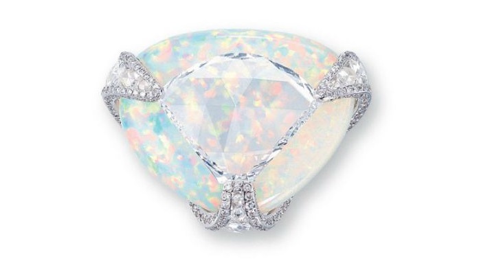 Diamond and Opal Ring Centering upon a shield-shaped rose-cut diamond weighing approximately 5.36 carats, overlapping a triangular-shaped white opal, joined by circular and oval-shaped rose-cut diamond openwork prongs with brilliant-cut diamond trim, mounted in 18k white gold