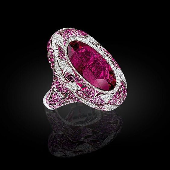 Sapphires and white diamonds leaves embrace the intense Rubellite stone.