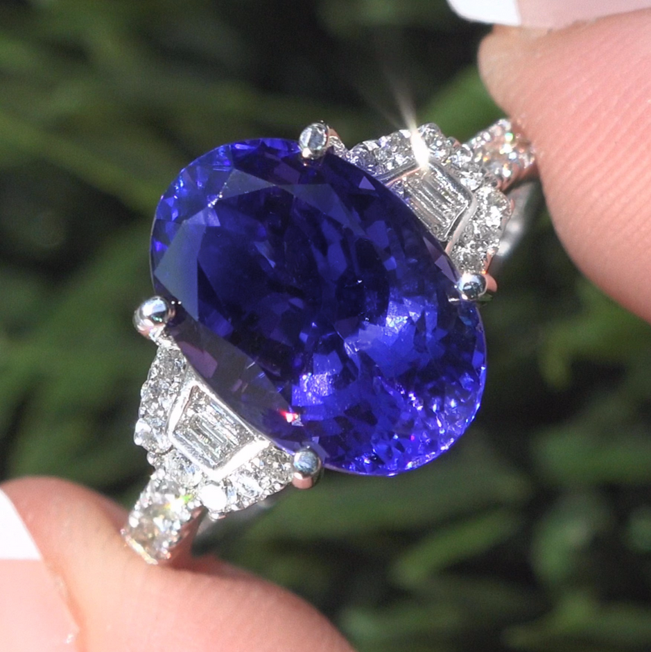  6.06 Total Carat Weight Natural Tanzanite & Diamond Ring. This stunning 5.60 carat (exact carat weight) Internally Flawless Clarity Tanzanite specimen features a stunning Violet-Blue color and is accented with a gorgeous array of natural round brilliant & baguette colorless & near colorless F-G color VS1-VS2 clarity diamonds totaling 0.46 carats. These diamonds light up this solid 18k white gold setting with sparkle and fire. The setting is a true fine jewelry masterpiece with an elegant custom design featuring 26 large accent diamonds. This extraordinary estate ring has it all and would be a great addition to any fine jewelry collection.