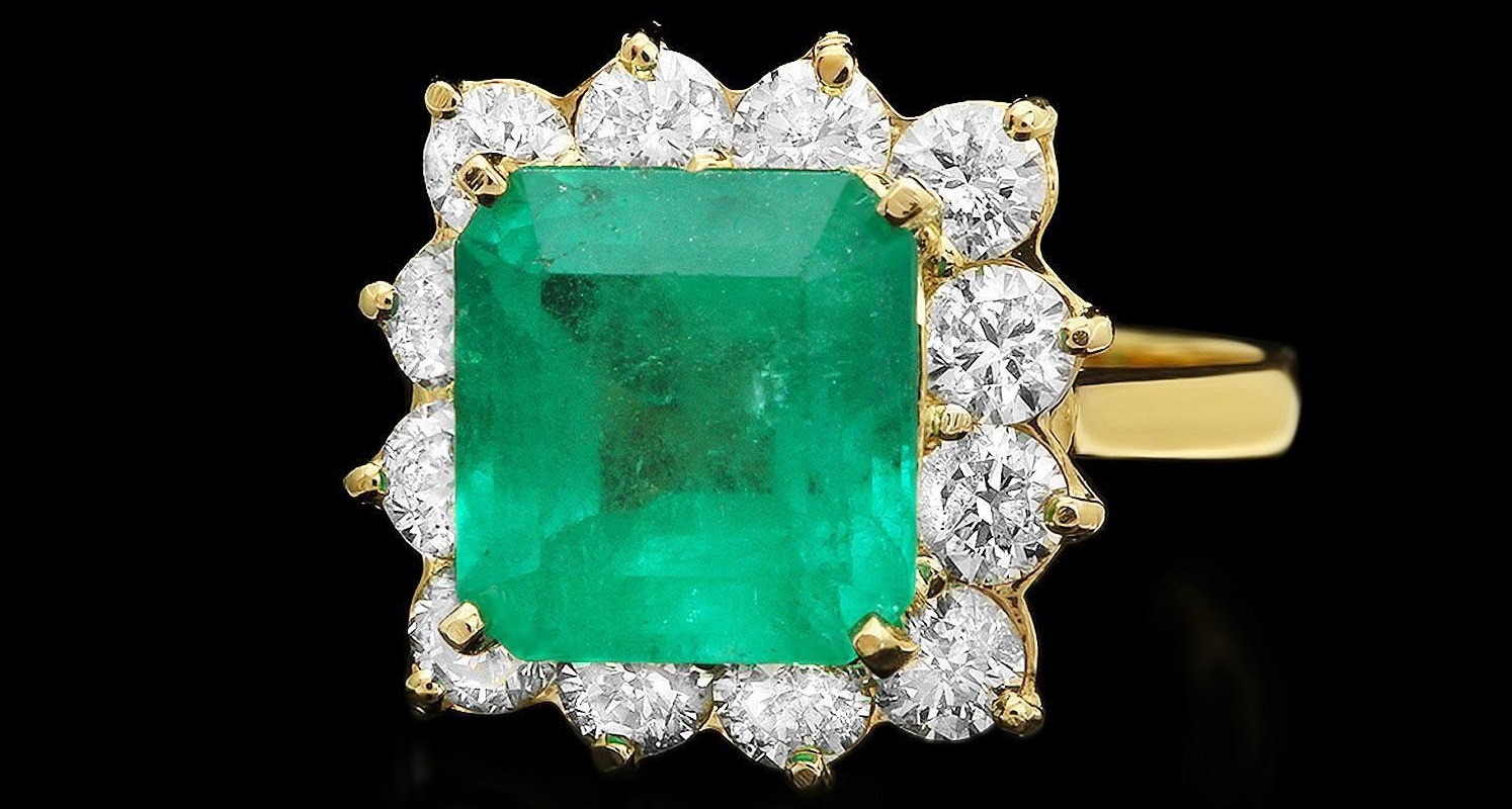 This elegant ladies ring is crafted in solid 14k Yellow Gold and features a 4.30 carat 100% Natural Emerald mined from Colombia + accented with 12 sparkling eye-clean natural Diamonds, totaling 1.80 carats. 