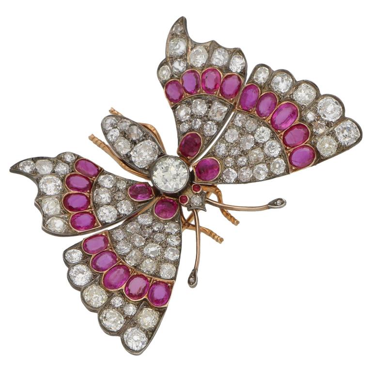 A stunning butterfly brooch set in 18ct rose gold and silver, featuring sprung set fluttering wings grain set with diamonds and rubies. The body of the butterfly is grain set with diamonds, featuring one large 1.44ct Old European cut diamond in the centre and with cabochon cut ruby eyes and diamond set antennae. The brooch measures 62mm in width and 40mm in length with a tube hinge pin and C-shaped safety clasp. The total diamond weight is approximately 17.20 cts, H/I colour and Si clarity, and the total ruby weight is approximately 6.00 cts, reddish purple 4/5 (GIA) and Si clarity. Gross weight: 25.50 grams.
